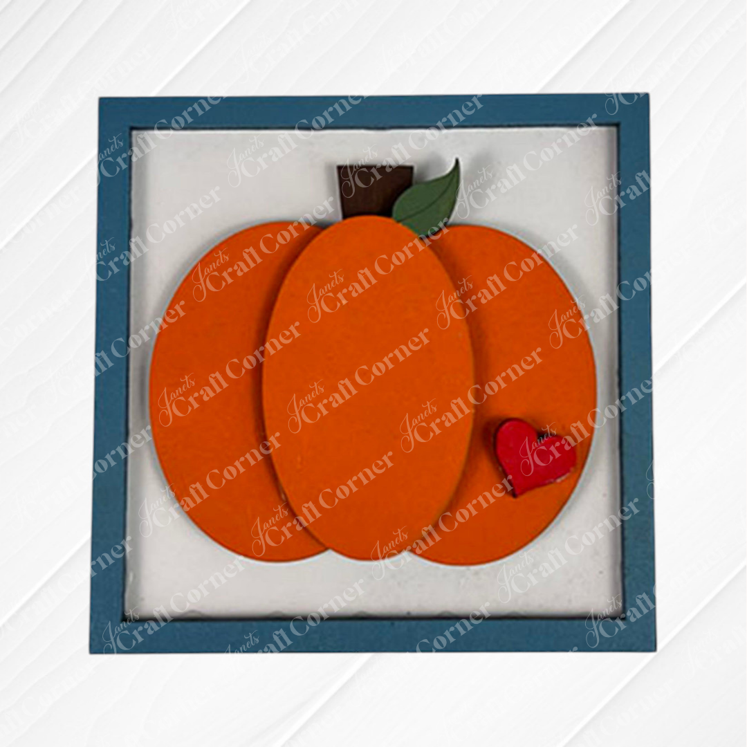 The Pumpkin Spice Squares by Janet's Craft Corner is a framed artwork featuring layered orange wood in a pumpkin shape, with a brown stem, green leaf, and red heart—perfect for tiered tray decor or your Swappable Squares collection.