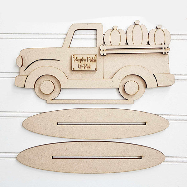 The Pumpkin Truck Mini Shelf Sitter from Janet's Craft Corner brings pumpkin truck charm to your personalized home décor. This DIY home decor kit features a wooden cutout of a truck labeled "Pumpkin Patch U-Pick," perched on two oval wooden bases with slots, making it a delightful focal point against any white background.