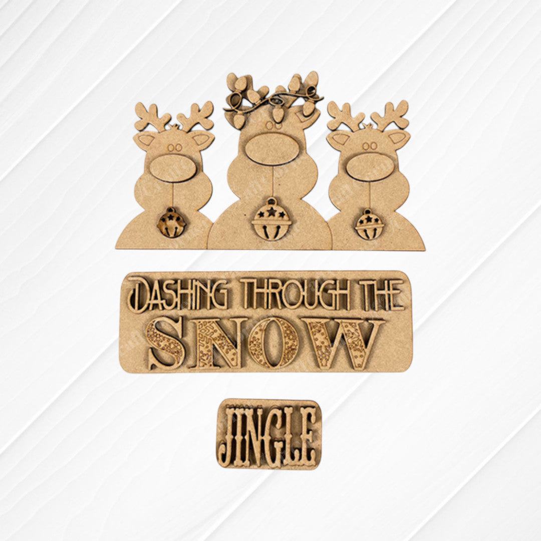 The Reindeer Interchangeable Insert from Janet's Craft Corner features three antlered reindeer set against a textured burlap background, with signs that read "Dashing Through the Snow" and "Jingle." As a DIY home decor kit, it is perfect for adding festive charm to any space.