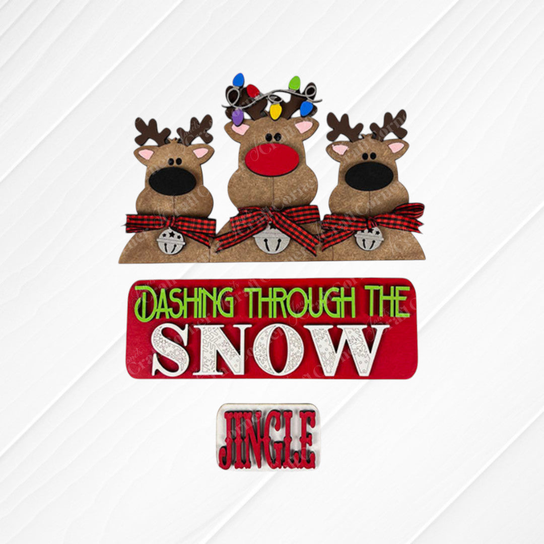 Janet's Craft Corner presents the Reindeer Interchangeable Insert DIY home decor kit, featuring three charming cartoon reindeer with red noses, plaid bow ties, antlers, and bells. This delightful piece adds a festive touch to your holiday sign with the message "Dashing Through The Snow" and "Jingle" at the bottom, making it ideal for creating a warm and inviting seasonal ambiance.