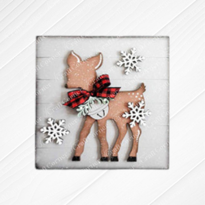 The Mistletoe Swappable Squares DIY craft kit from Janet's Craft Corner lets you create seasonal home decor—choose from 4 designs, including wood cut-outs perfect for tiered tray displays on a white wooden background.