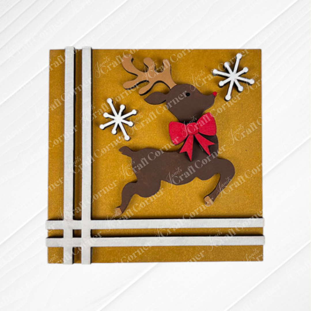 The Merry Christmas Squares card from Janet's Craft Corner features a leaping reindeer, red bow, snowflakes, and ribbon accents—ideal for DIY holiday decor or to display with your Swappable Square Displays.