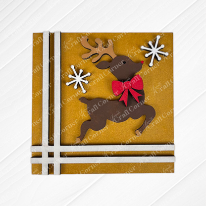 The Merry Christmas Squares card from Janet's Craft Corner features a leaping reindeer, red bow, snowflakes, and ribbon accents—ideal for DIY holiday decor or to display with your Swappable Square Displays.