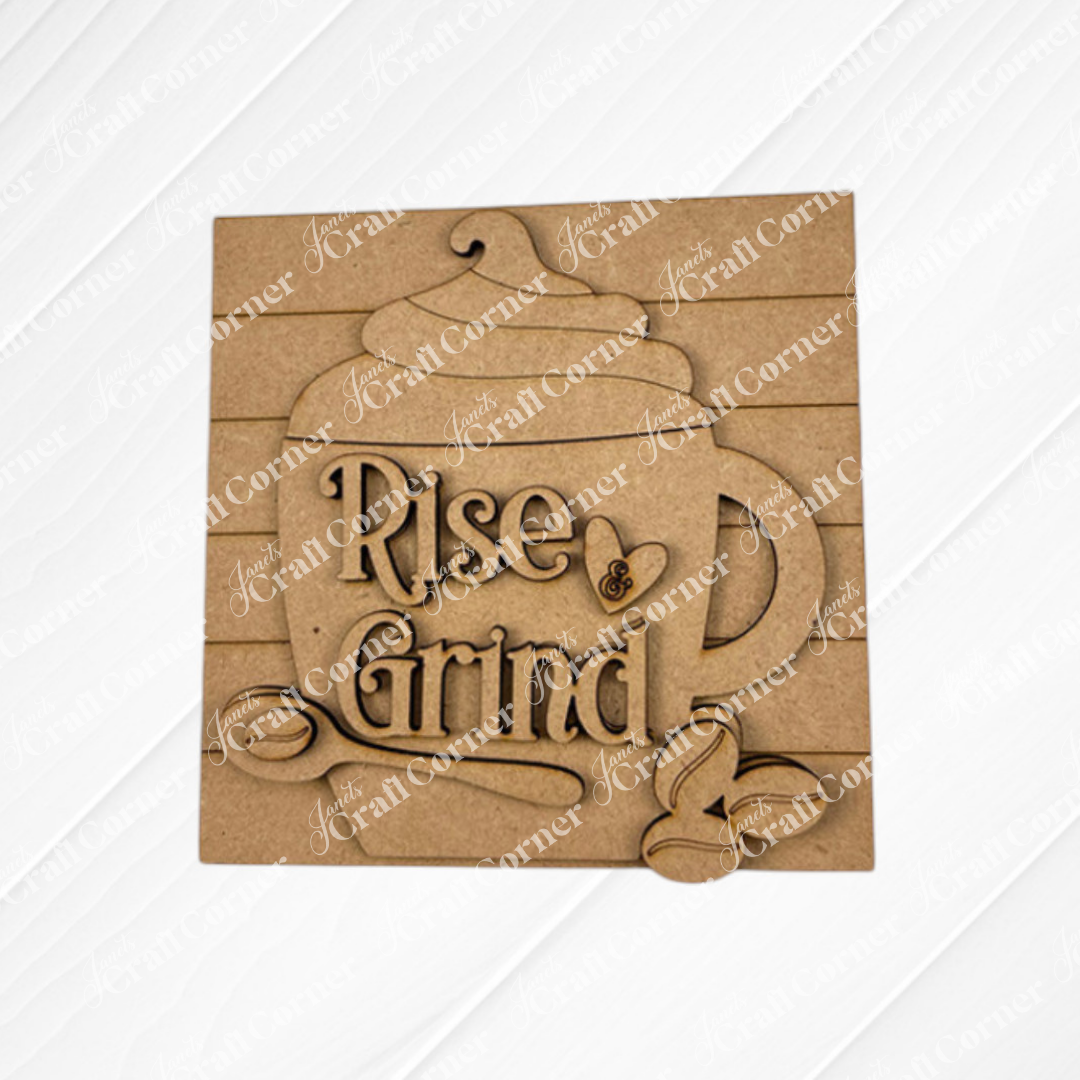 The Coffee Swappable Squares DIY craft kit by Janet's Craft Corner features a wooden coffee cup cutout with whipped cream, beans, spoon, and “Rise & Grind” text—perfect for coffee lovers or unique seasonal home decor.