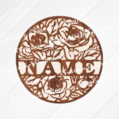 The Nursery Name Wall Hanger by Janet's Craft Corner is a round, unfinished wood sign with detailed floral designs and a central "NAME" area, ideal for customizing as a unique wall décor or craft project.