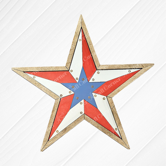 The Rustic Star Shelf Leaner by Janet's Craft Corner features a five-pointed star with a wooden border, unfinished wood craft style, red, white, and blue sections with brass rivets—perfect for leaning on a shelf against a white background.