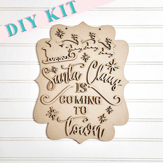 The "Santa is Coming to Town Door Hanger" from Janet's Craft Corner embodies the holiday spirit with its laser-cut design of Santa Claus, reindeer, and snowflakes. Featuring the festive text "Santa Claus is Coming to Town," it makes an ideal decoration for your door against a white panel backdrop.