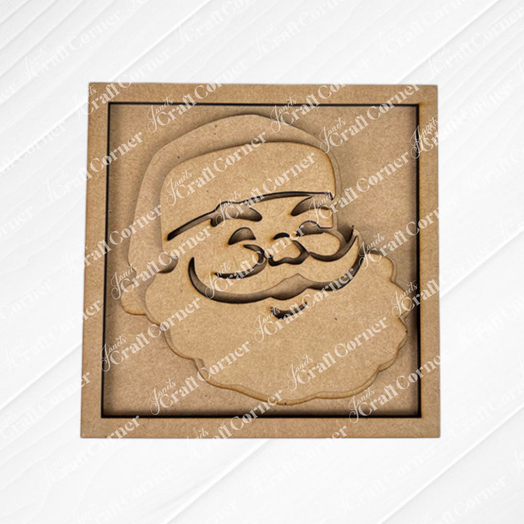 Santa Squares by Janet's Craft Corner: a laser-cut wooden ornament with a smiling Santa face in a square frame—ideal for DIY holiday decor or adding to your Swappable Squares kit. Shown on a diagonal textured white background.