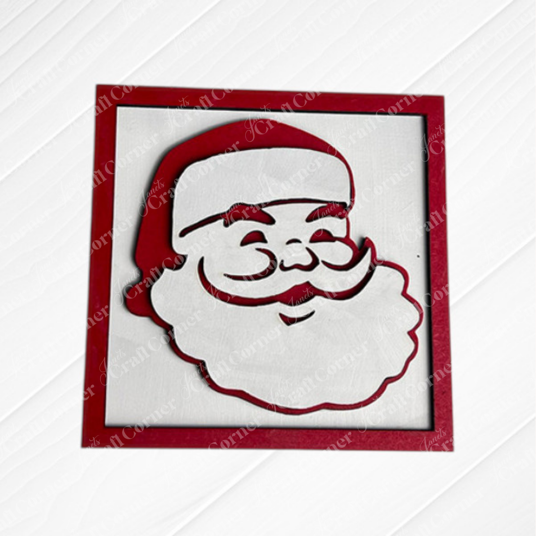 Santa Squares by Janet's Craft Corner features a red and white, square-framed Santa Claus cutout—complete with hat, mustache, and beard—perfect as a Swappable Squares craft kit for festive DIY home decor on a textured white background.