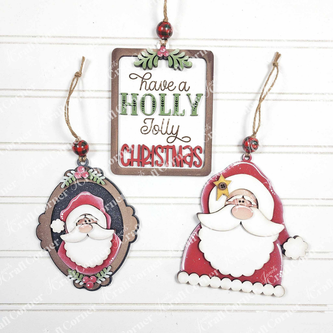 Janet's Craft Corner Santa Ornaments—DIY holiday craft kit (Set of 1)—features a rectangular “Have a Holly Jolly Christmas” sign and two festive accents, oval and Santa-shaped, perfect for your seasonal crafting fun.