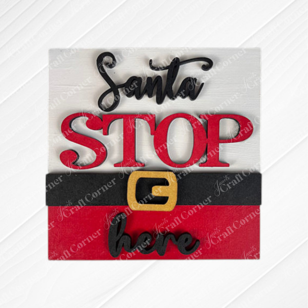 Santa Squares from Janet's Craft Corner is a wooden sign craft kit featuring layered “Santa STOP here” text, a bold red "STOP" with Santa’s belt, and a white/red background with subtle diagonal patterns—perfect for DIY seasonal décor.