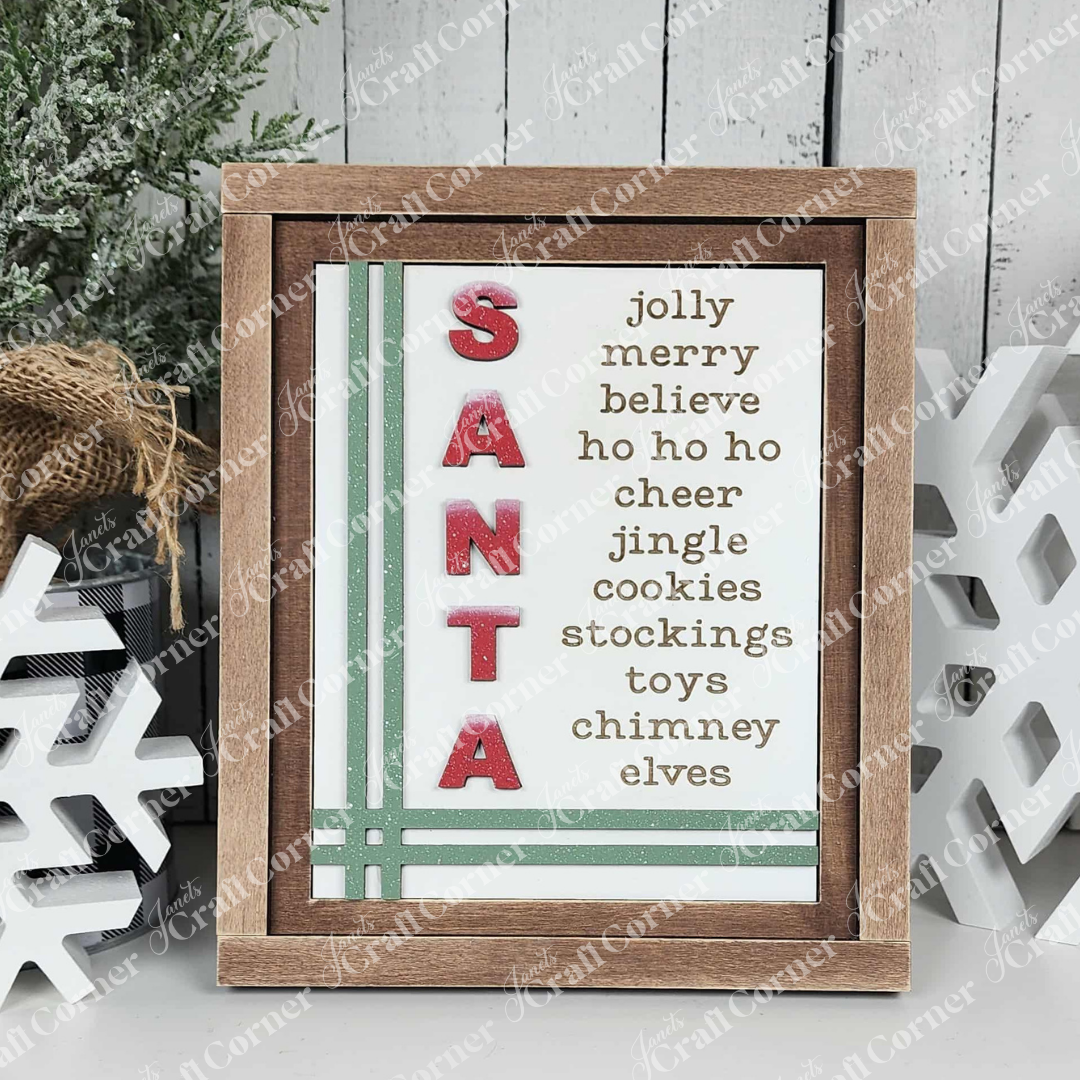 Janet's Craft Corner North Pole Switchable Farmhouse Signs feature "SANTA" in red glitter with festive words like "jolly," "merry," and "toys," green stripes, and pair perfectly with snowflake decorations for charming DIY holiday decor.