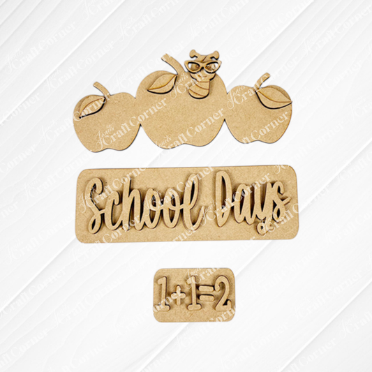 Add a touch of whimsy to your farmhouse decor with Janet's Craft Corner's School Days Interchangeable Insert. This DIY home decor kit features wooden cutouts of three apples with a worm wearing glasses, the phrase "School Days," and the equation "1+1=2," all set against a plain background.