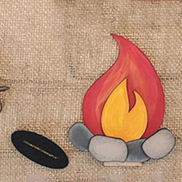 Featuring the S'mores - Tiered Tray Kit by Janet's Craft Corner, this illustration captures a campfire with vibrant red and orange flames, adding a cozy touch to your home décor. The scene is surrounded by gray rocks and set against a textured burlap background for an inviting look.