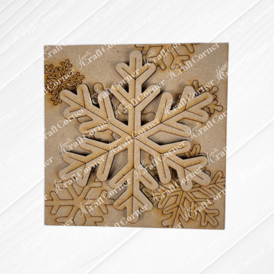 Snow Squares by Janet's Craft Corner is a square wooden sheet with laser-cut snowflake designs in different sizes that partially overlap on natural wood—perfect for DIY seasonal home decor and craft projects.