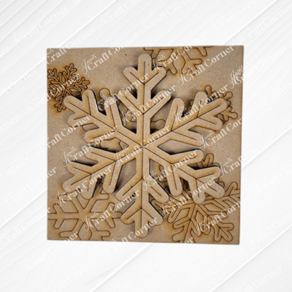Snow Squares by Janet's Craft Corner is a square wooden sheet with laser-cut snowflake designs in different sizes that partially overlap on natural wood—perfect for DIY seasonal home decor and craft projects.