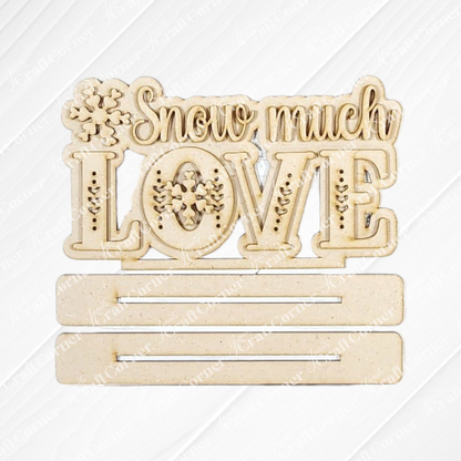 Janet's Craft Corner’s Valentine Snowmen Decor Set features a wooden sign with “Snow much LOVE,” snowflake designs, and two customizable slots—ideal to pair with your favorite DIY craft kit or wood cut-outs.