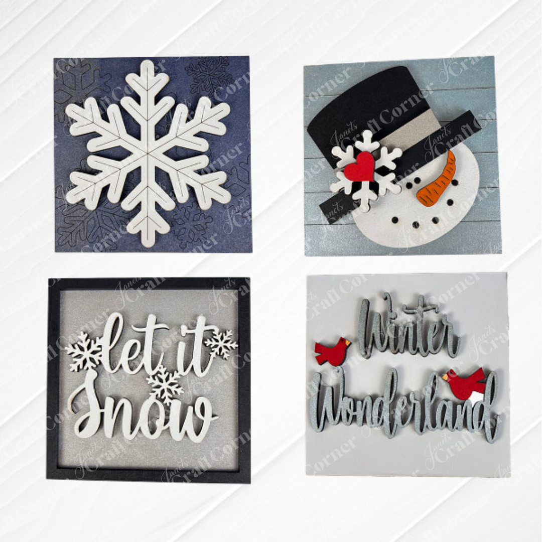 Snow Squares from Janet's Craft Corner: four swappable signs for seasonal decor—white snowflake on blue, snowman face with hat and carrot nose, "let it snow" in script, and "Winter Wonderland" with two red cardinals.