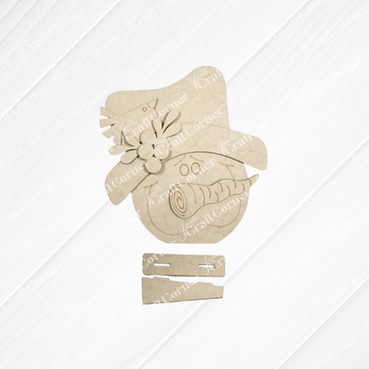 Janet’s Craft Corner Snowman Face Shelf Sitter is a DIY home decor craft kit featuring an unassembled snowman with a hat, floral accents, and two rectangular base pieces—perfect for adding handmade charm to your winter home. Displayed on a light, textured background, this set of 1 makes a fun and creative project.