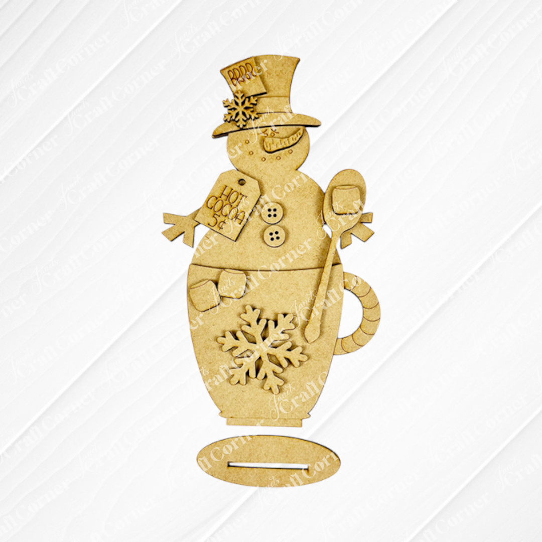 This DIY kit from Janet's Craft Corner includes a Snowman Hot Cocoa Mug Shelf Sitter featuring a snowman in a top hat, with button and snowflake details, holding a spoon and "Hot Cocoa 5¢" sign for unique seasonal home décor.