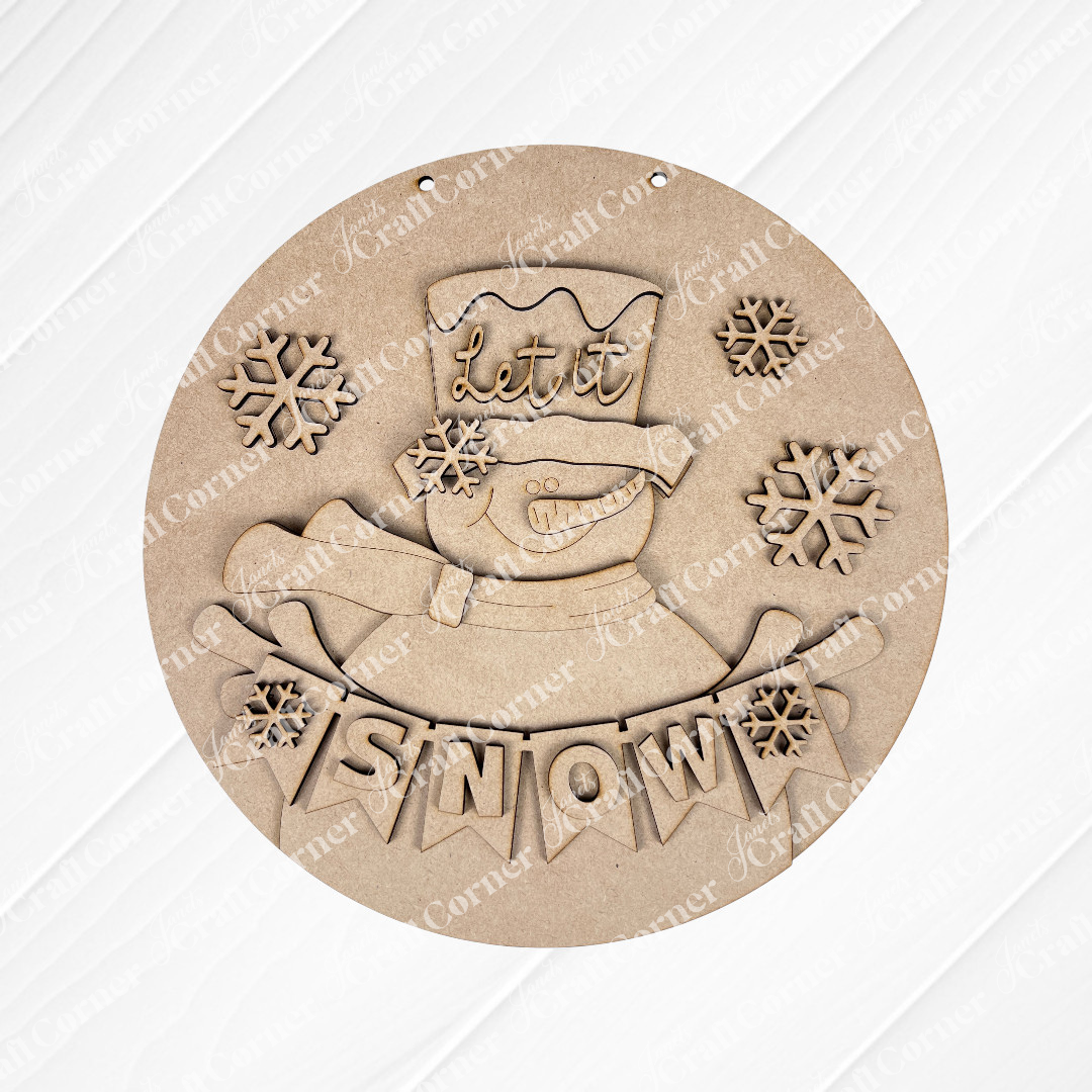 Create charming holiday decor with Janet's Craft Corner's DIY kit: the Snowman Let It Snow Door Hanger, featuring a smiling snowman in a top hat that reads "Let it" and banner saying "SNOW" on burlap, perfect for any seasonal project.