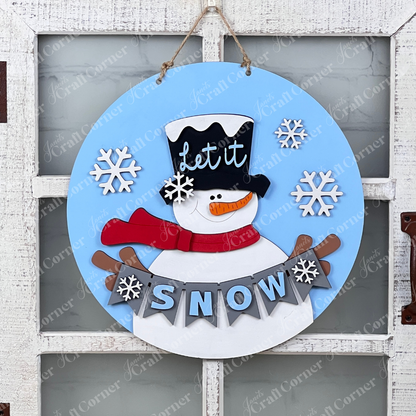 Add a touch of holiday charm to your rustic white door with Janet's Craft Corner's Snowman Let It Snow Door Hanger. This delightful round blue decoration showcases a snowman wearing a top hat and red scarf. The words "Let it" embellish the hat, while "SNOW," surrounded by whimsical snowflakes, is prominently displayed below.
