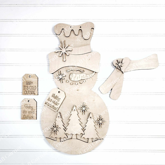 Janet's Craft Corner Snowman Trees Wall/Door Hanger DIY kit includes an unpainted snowman with separate hat, scarf, engraved trees, snowflakes, and festive signs—perfect for creating seasonal home decor. Set of 1.