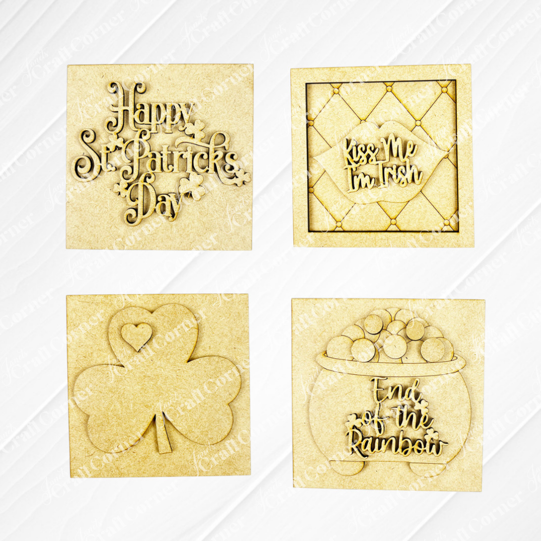 Janet's Craft Corner St Patricks Squares includes four wood cut-outs: "Happy St. Patrick’s Day" with clovers, "Kiss Me I’m Irish," a shamrock heart, and a pot of gold—ideal Swappable Squares for tiered tray decor.