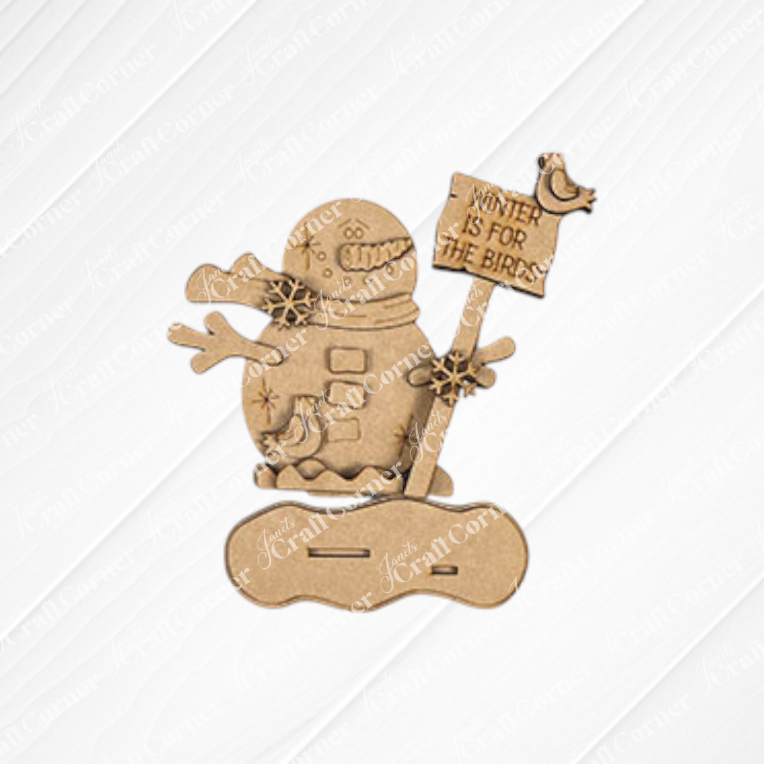 Create a festive atmosphere with the Standing Snowman Mini Shelf Sitter from Janet's Craft Corner. This winter-themed display includes a "Winter is for the Birds" sign and is shown on a white shiplap background. Use the DIY kit to add an enchanting touch to your winter décor.