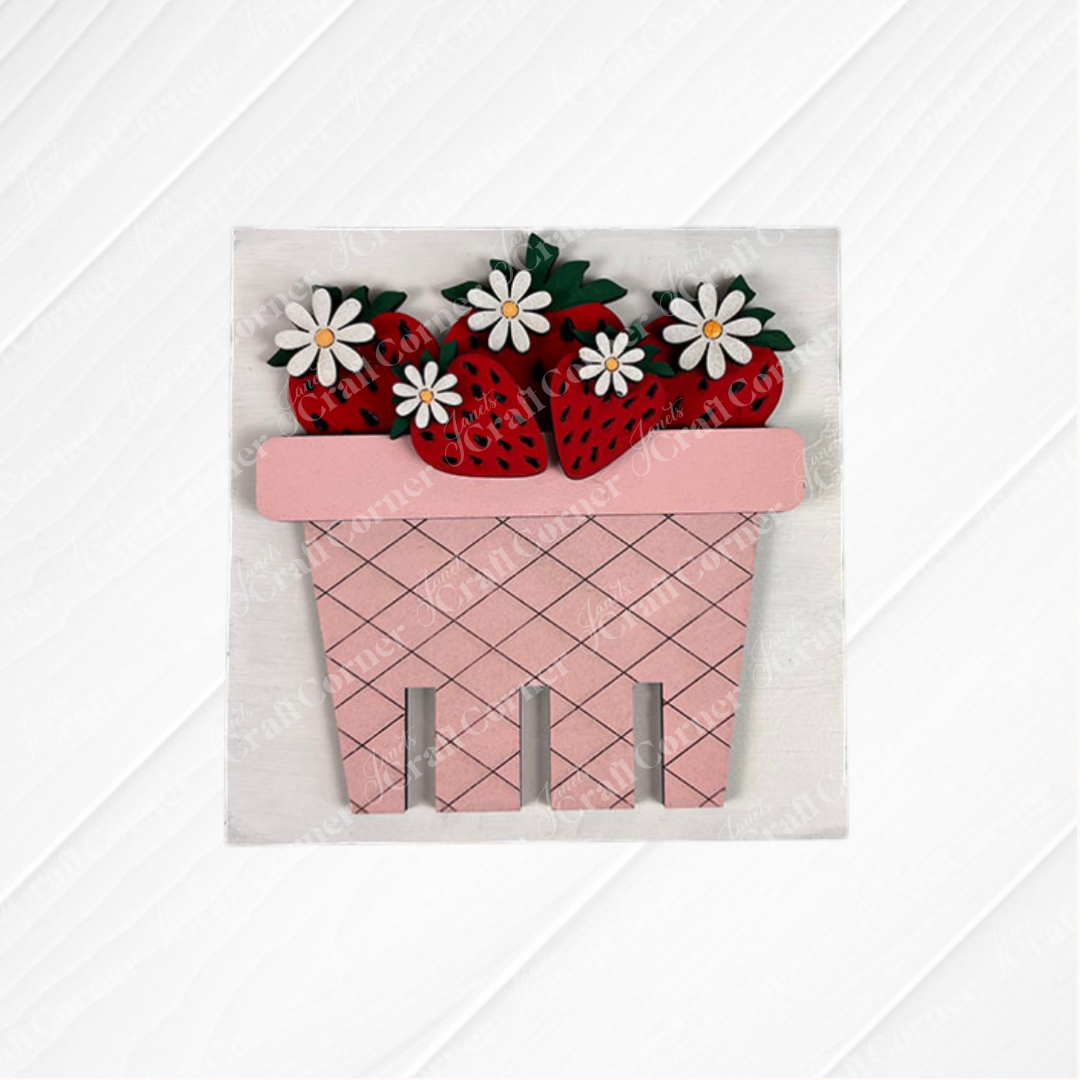 The Strawberry Swappable Squares DIY kit by Janet's Craft Corner features a pink wooden basket with crisscross pattern, red strawberries, and white daisies—ideal for tiered tray decor or pairing with wood cut-outs.