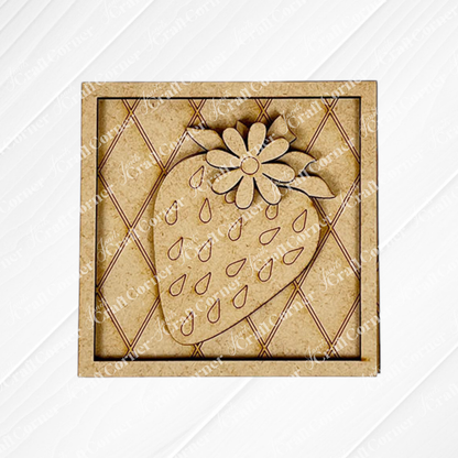 The Strawberry Swappable Squares DIY craft kit from Janet's Craft Corner features a wooden square coaster with a carved strawberry and flower, teardrop seeds, and a diamond-patterned light wood background—perfect for seasonal tiered trays.