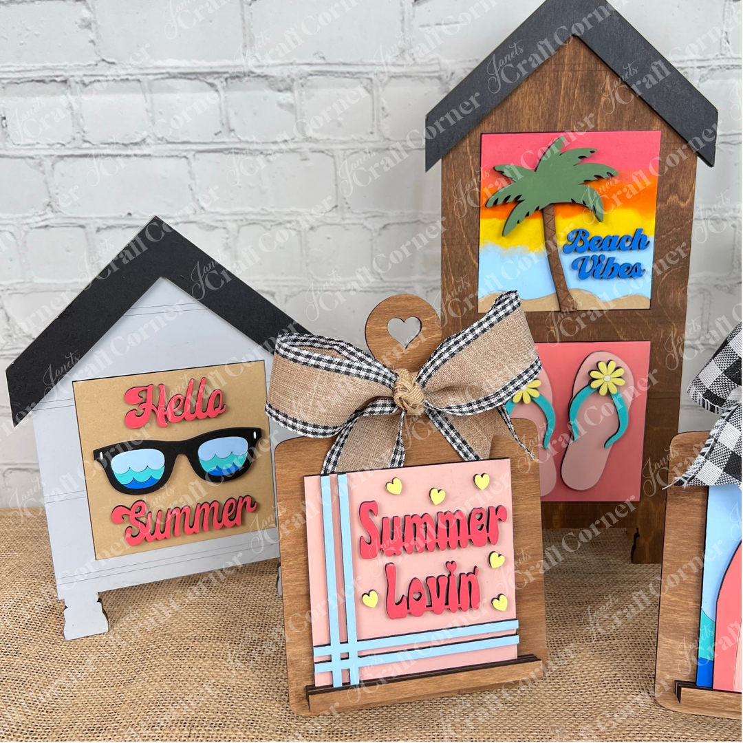 Showcase Janet's Craft Corner's Summer Lovin Swappable Squares DIY kit—summer wood cut-outs and tiered tray decor with "Hello Summer," "Summer Lovin'," "Beach Vibes," sunglasses, palm trees, flip flops, ribbon bow, and mix-and-match squares.