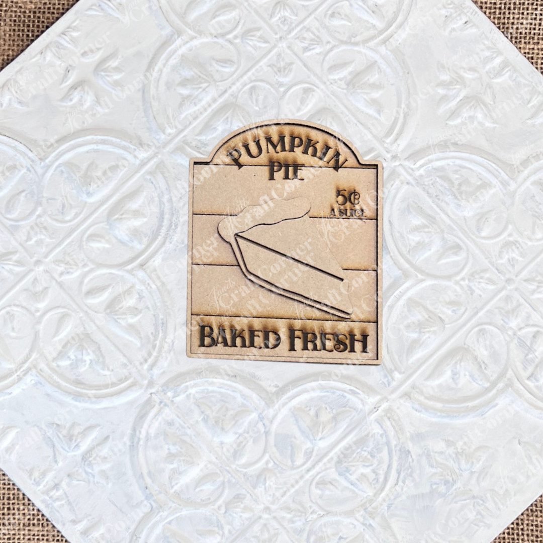 The Thankful Mini Shelf Sitters from Janet's Craft Corner is a DIY decor craft kit featuring a wooden sign engraved with "Pumpkin Pie," "5¢ a slice," and "Baked Fresh," perfect for adding charm to your seasonal home.