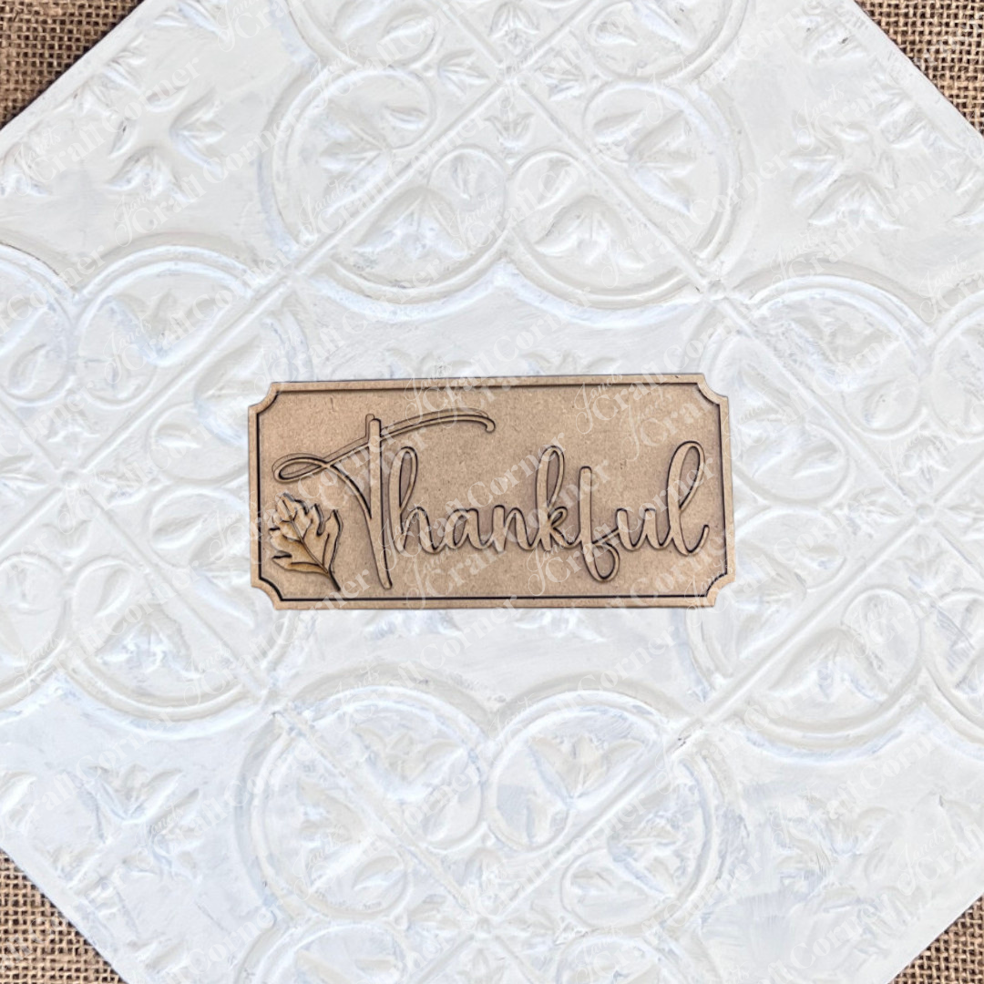 The Thankful Mini Shelf Sitter by Janet's Craft Corner is a DIY seasonal home decor kit featuring "Thankful" engraved in cursive with a leaf design—perfect for your Thankful Decor Set or creating unique personalized decorations.