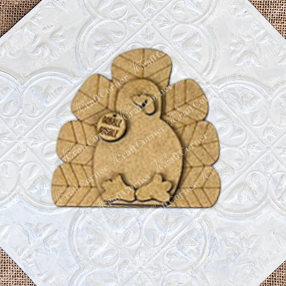 The Give Thanks/Thanksgiving Tiered Tray Kit by Janet's Craft Corner includes a DIY wooden turkey craft kit with a "gobble gobble" tag. It's perfect for enhancing your home décor and adding charm to your tiered tray setup against a simple backdrop.