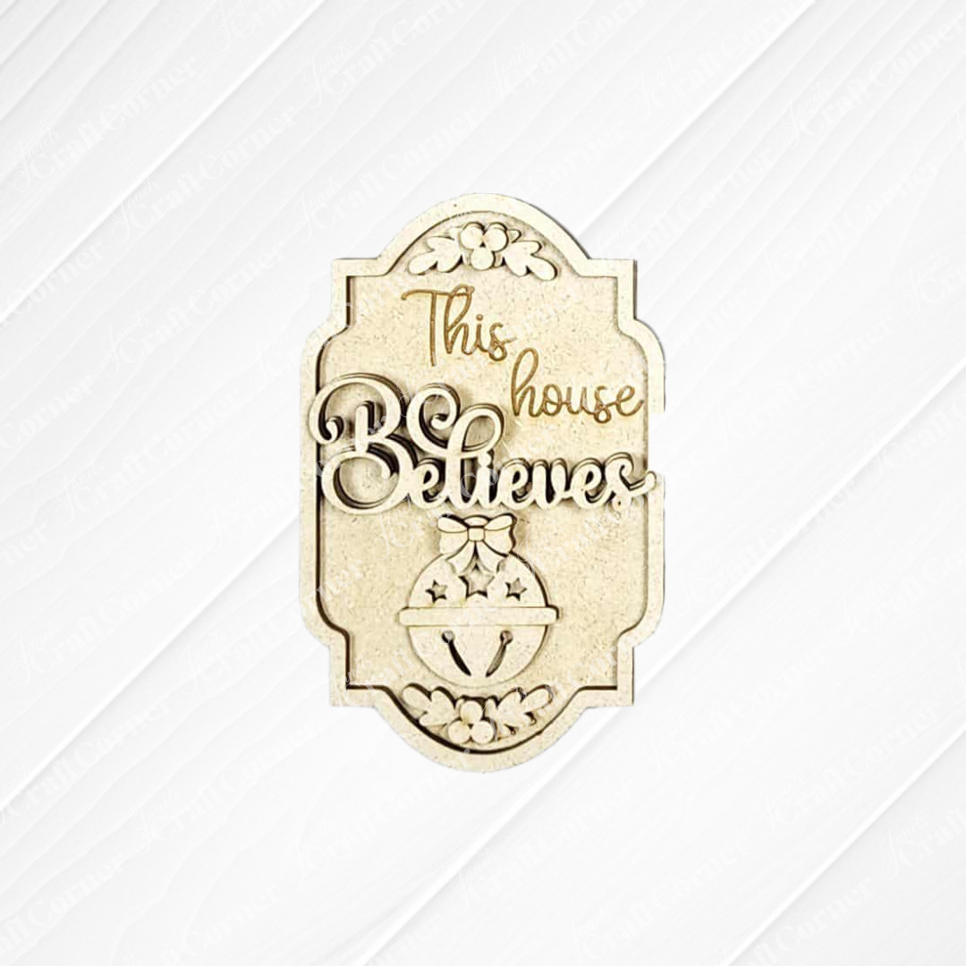 Janet's Craft Corner North Pole Ornaments DIY kit features a wooden plaque with "This house believes," engraved floral accents, a jingle bell motif, and a textured light background—perfect for seasonal home decor crafting. Set of 1.