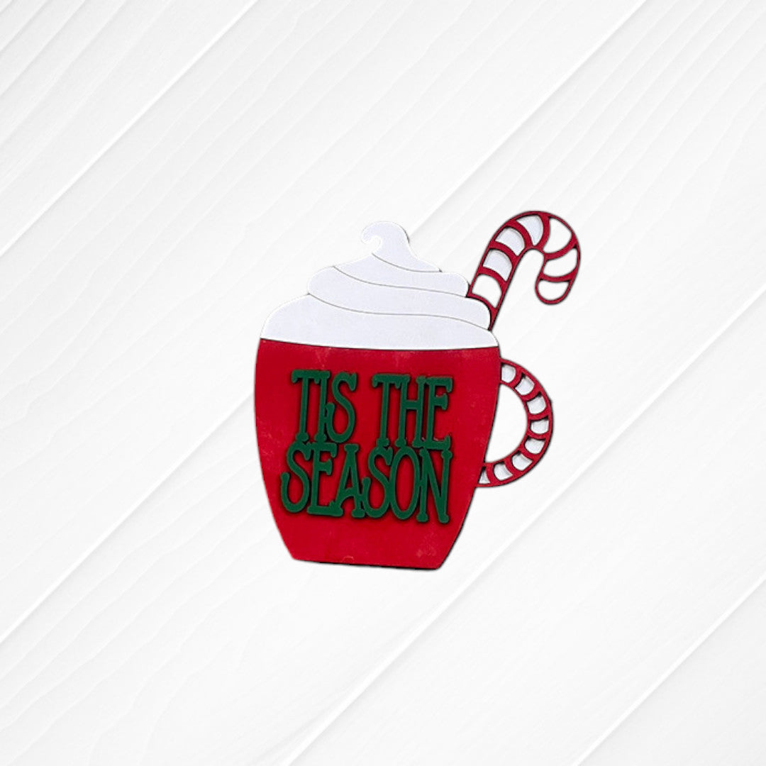 The Heartland Peppermint Mocha Mini Shelf Sitters - Painted features a red mug topped with whipped cream and two candy canes, accented with green “TIS THE SEASON” text on a white wooden background for a festive holiday display.