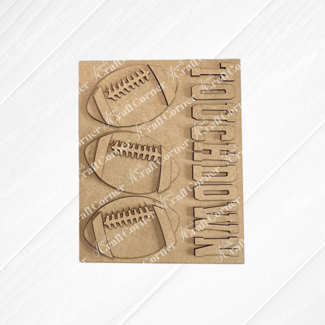 Add a sporty flair to your interchangeable seasonal displays or DIY home decor kits with Janet’s Craft Corner Football Farmhouse Signs—a brown card featuring three football shapes and the word “TOUCHDOWN” cut out vertically on the right, all set against a light wood textured background.