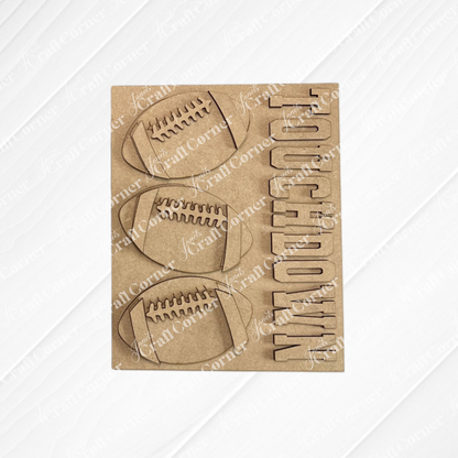 Add a sporty flair to your interchangeable seasonal displays or DIY home decor kits with Janet’s Craft Corner Football Farmhouse Signs—a brown card featuring three football shapes and the word “TOUCHDOWN” cut out vertically on the right, all set against a light wood textured background.