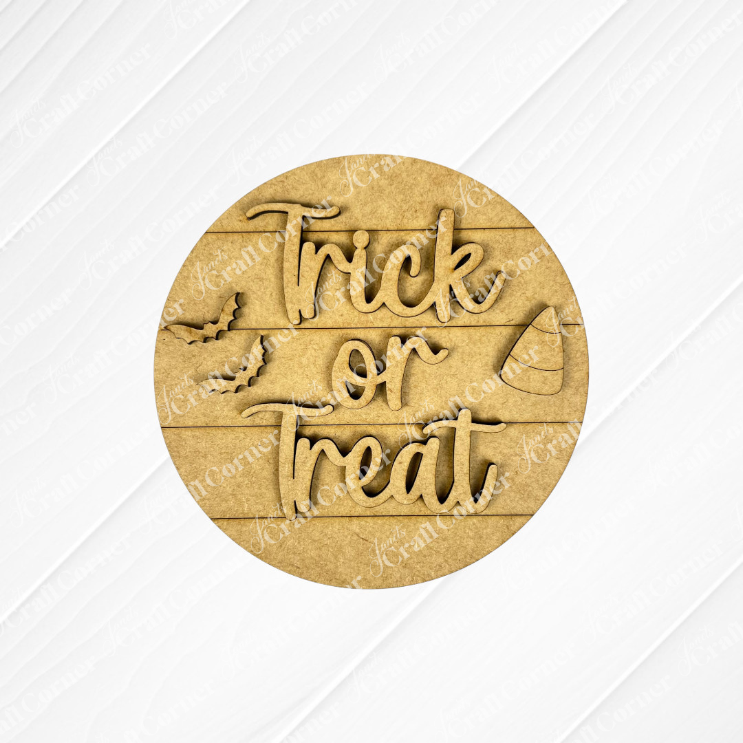 Janet's Craft Corner Halloween Mini Shelf Sitters is a DIY home decor craft kit featuring a round wooden sign with "Trick or Treat," playful font, bat and candy corn cutouts, on a light wood plank—perfect for Halloween decorations.