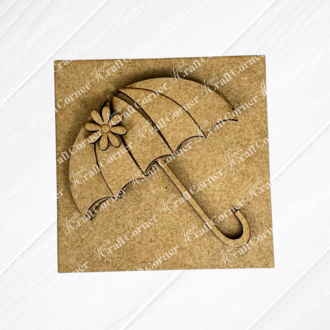 The Hello Spring Squares by Janet's Craft Corner is a square wooden plaque with a cutout umbrella design, flower detail, and scalloped edges. Its light wood texture makes it ideal for tiered tray decor as a Swappable Squares piece.