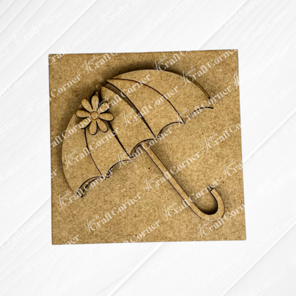 The Hello Spring Squares by Janet's Craft Corner is a square wooden plaque with a cutout umbrella design, flower detail, and scalloped edges. Its light wood texture makes it ideal for tiered tray decor as a Swappable Squares piece.