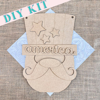 The Uncle Sam Gnome Door Hanger from Janet's Craft Corner includes pre-cut pieces for a charming door decoration, featuring a mustached face with stars above it and the word "America" across the top. The parts are beautifully arranged on a burlap background with a floral pattern, making it an ideal addition to your Independence Day decor.