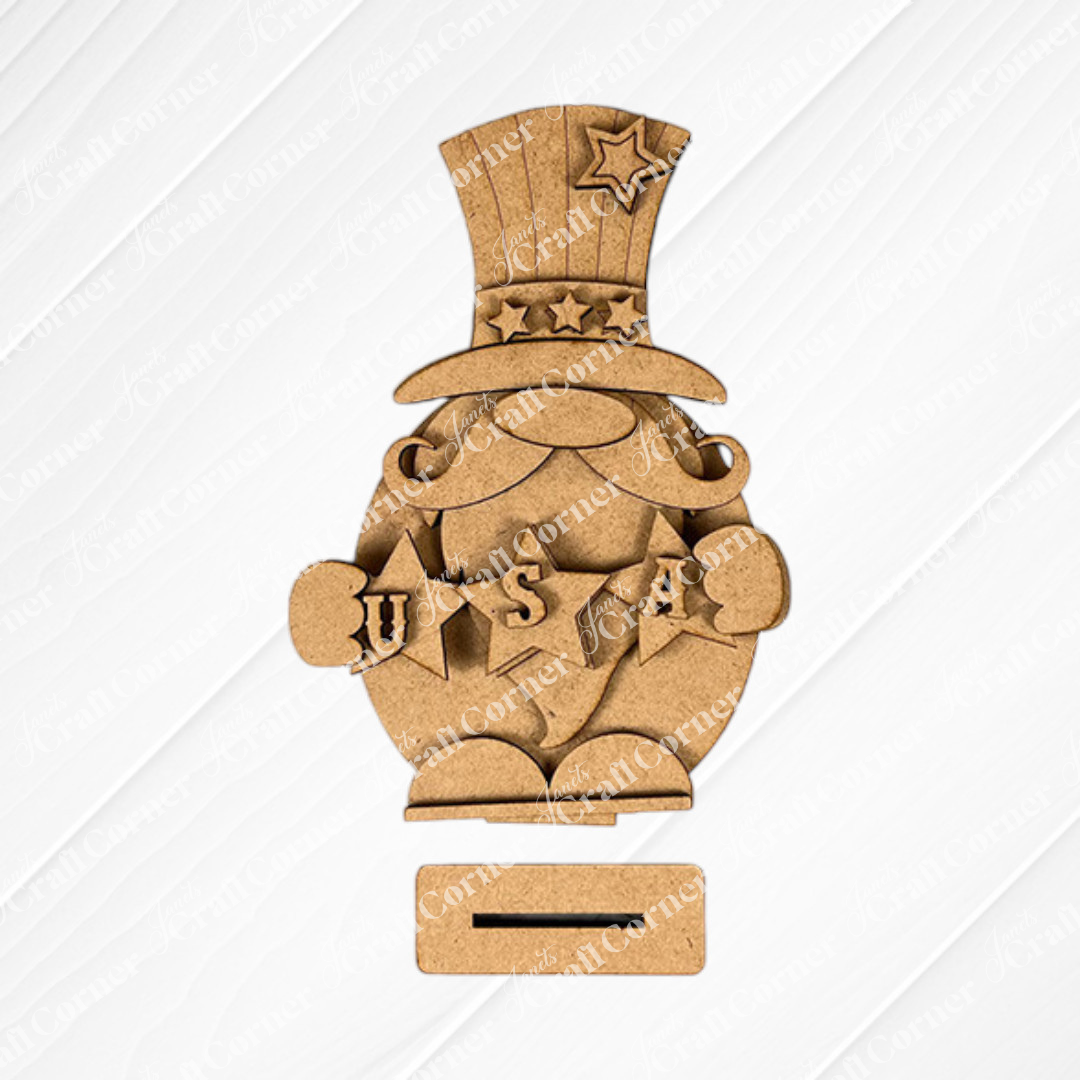 The Uncle Sam Gnome Shelf Sitter by Janet's Craft Corner is a DIY seasonal home decor craft kit featuring a wooden gnome in patriotic style, adorned with stars and "U S A," ideal for adding charm to any textured light background.