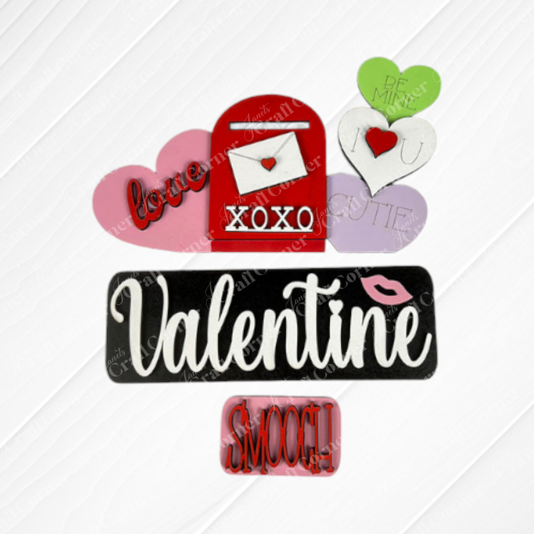 Celebrate Valentine's Day with the Valentine Interchangeable Insert - Painted from Janet's Craft Corner. This charming decorative arrangement includes a red mailbox embellished with hearts and sweet messages such as "love" and "XOXO," alongside a black and white sign featuring the word "Valentine" with a pink kiss mark. Perfect for adding rustic charm to your home, this piece offers versatile decor options for seasonal joy.