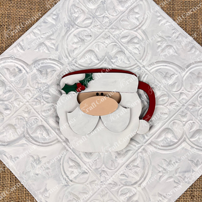 The Vintage Santa Cookies Decor Set DIY craft kit by Janet's Craft Corner features a wooden Santa face ornament, painted in festive colors, on a white textured tile with burlap—ideal for holiday displays or charming home decor.