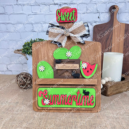 Introducing the **Summertime Watermelon Interchangeable Insert - Painted** by *Janet's Craft Corner*: This hand-painted decoration showcases a red checkered bow and a watermelon slice, paired with a green "Summertime" sign accented with white dots. Enhanced with black silhouettes of cows and white daisy flowers, this charming piece is perfect for your home decor.