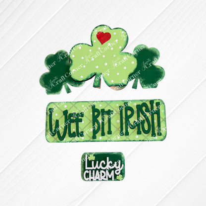 The "Wee Bit Irish Interchangeable Insert" by Janet's Craft Corner features cookies with green shamrocks and a red heart, ideal for displaying Irish pride. Text cookies say "Wee Bit Irish" and "Lucky Charm" on a burlap backdrop.