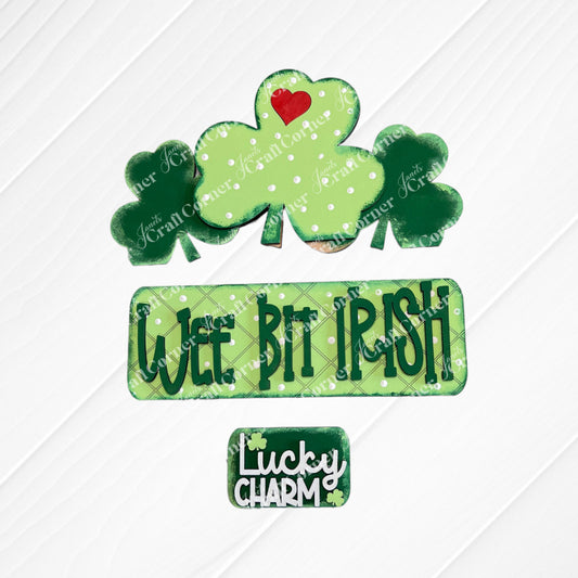 The "Wee Bit Irish Interchangeable Insert" by Janet's Craft Corner features cookies with green shamrocks and a red heart, ideal for displaying Irish pride. Text cookies say "Wee Bit Irish" and "Lucky Charm" on a burlap backdrop.