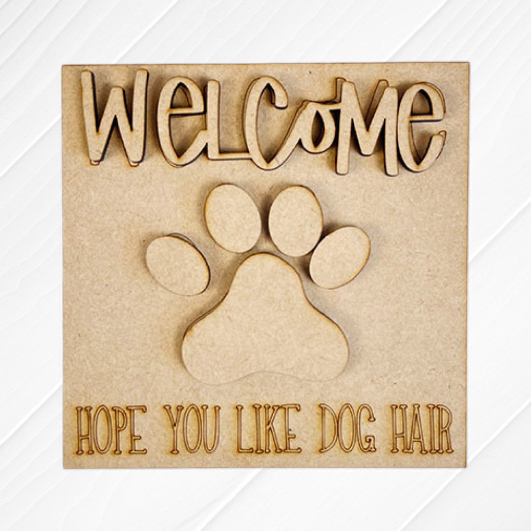 Dog Squares by Janet's Craft Corner features a wooden sign with "WELCOME" on top, a big paw print, and "HOPE YOU LIKE DOG HAIR" at the bottom—ideal for tiered tray decor or pairing with playful wood cut-outs.